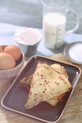 cooked pancakes, ingredients and cooking utensils for making pancakes,crêpe
