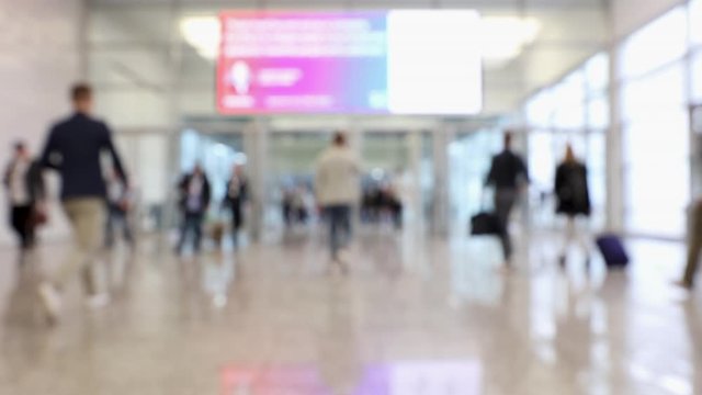 Blurred crowd of people passing through a conference center