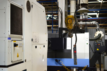 Crane hook of the overhead crane in the workshop of an industrial plant.  Push remote control switch for lifting crane in the factory