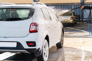 Self service high pressure car wash. Vehicle covered with foam