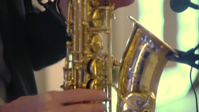 Closeup on the hands of a man playing the saxophone, Tilt cam.