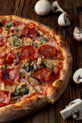 Close up of hot and spicy pizza with jalapeno, pepperoni and red onion on dark wooden background