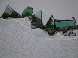 Bunte Glasscherben auf einem Mauervorsprung