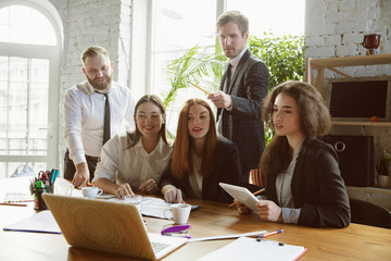 Already done. Group of young business professionals having a meeting. Diverse group of coworkers discussing new decisions, plans, results, strategy. Creativity, workplace, business, finance, teamwork.