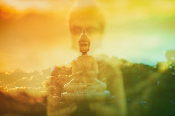 Double exposure of a Buddha figure meditating on the rock
