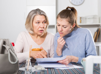 Woman and adult daughter fill out paperwork