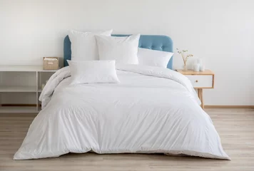 Foto op Aluminium Interior with white bed linen on the sofa. Bedroom with bed, white bedding, and bedside table. White pillows, duvet and duvet case on bed with blue headboard. Front view. © Vera