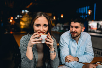 romantic couple in restaurant. woman holding cup of coffee