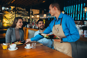 couple eating lunch in restaurant. waiter serving
