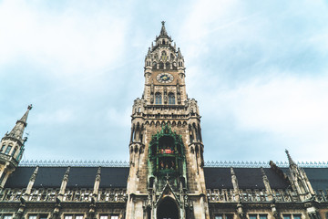 Obraz premium The New Town Hall, Neues Rathaus on Marienplatz main square, city government building with a tower clock. Gothic style. Photographed from below. Wide shot.