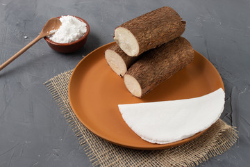 Tapioca, a traditional brazilian snack made from cassava flour. Cassava and dry coconut on the back. 