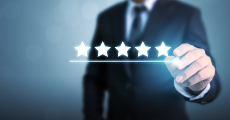 Hand of businessman drawing line under five five star symbol to increase rating of company concept