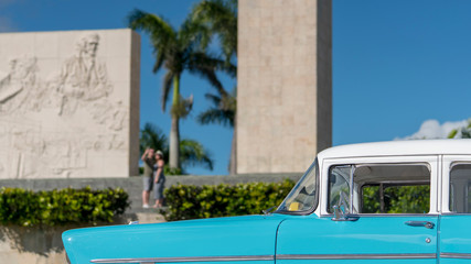 baby-blue cuban classic car in front on a cuban historic monument in santa clara, cuba
