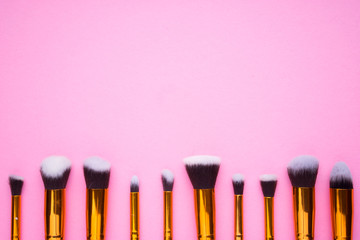Creative arrangement of cosmetics products on pink background.