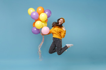 Surprised woman in sweater hat posing isolated on blue background. Birthday holiday party, people...