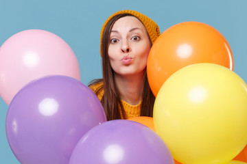 Young woman girl in sweater hat posing isolated on blue background. Birthday holiday party, people...