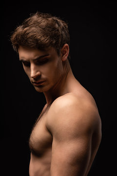sexy man with bare muscular torso isolated on black