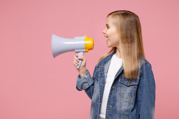 Side view of little blonde kid girl 12-13 years old in denim jacket posing isolated on pastel pink background children portrait. Childhood lifestyle concept. Mock up copy space. Scream in megaphone.