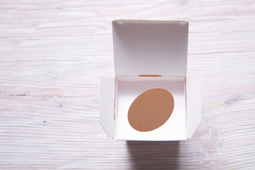 Top view, wthite cream bottle inside of carton cox, case on wooden backgrouns, copy space, mock up