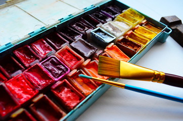 watercolor paints and paintbrushes for painting closeup. Selective focus.