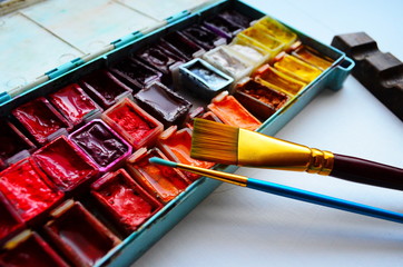 watercolor paints and paintbrushes for painting closeup. Selective focus.