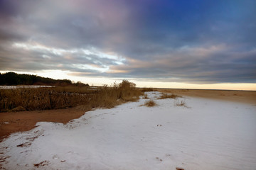 Sunset on the deserted beach of the Gulf of Finland in winter.