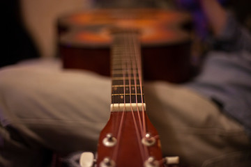 Fototapeta premium Musical instrument acoustic guitar. Home playing guitar lessons. Exercises for the development of musicality. Screw tool.