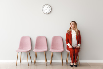 Young woman waiting for job interview indoors - obrazy, fototapety, plakaty