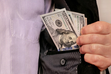 A man shows dollars hidden in his inner jacket pocket. Underground sales of dollars_