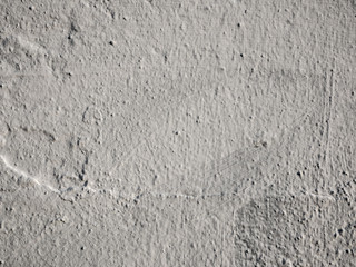 Old gray unevenly painted concrete wall. Texture of gray damaged plaster on the wall.