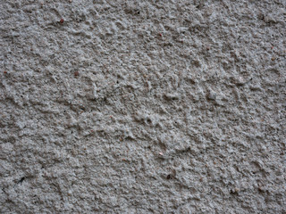 Old peeling paint on the wall.   Dark gray abstract background. Beautiful gray textured stucco on the wall. Background from gray stucco.