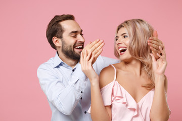 Obraz na płótnie Canvas Laughing young couple two guy girl in party outfit celebrating posing isolated on pastel pink background. People lifestyle Valentine's Day Women's Day birthday holiday concept. Looking at each other.