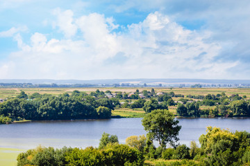Fototapeta na wymiar Summer landscape with river, green shores and beautiful sky with white clouds_