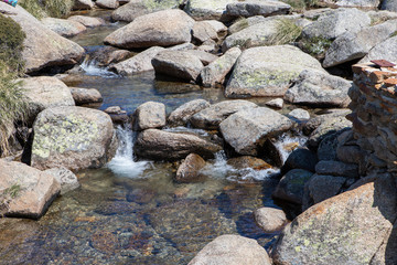 Naklejka na ściany i meble Water flowing between the rocks.