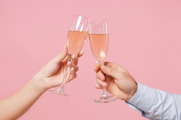 Close up cropped photo of female, male hold in hands glass of champagne isolated on pastel pink background. Copy space advertising mock up. Valentine's Day Women's Day birthday holiday party concept. - obrazy, fototapety, plakaty