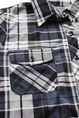 Flannel casual shirt close up vertical view of stylish fashion clothes. Dark gray, black and white color top, button down simple plaid shirt with tartan checkered pattern 