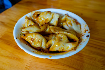 Local delight. Chinese ravioli with hot spicy sichuanese sauce and pepper. Chengdu city, China