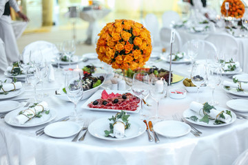 Holiday table setting decorated with flowers and candles.