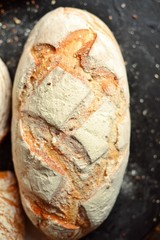 Bakery products. Crispy, beautiful bread on a dark background. Buckwheat, without yeast, wheat bread with flax and sunflower seeds. Top view, place for text.
