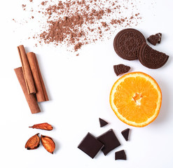 White background with cinnamon, orange, chocolate, chocolate cookies. Free space in the center for your design.