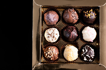 Box with Chocolate Pralines on dark Background. Copy Space