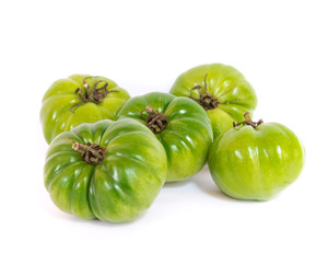 Heap of unripe organic heirloom Beefsteak tomatoes isolated on white