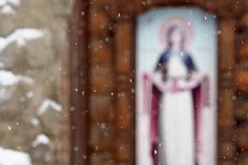 Snowing, chapel with an icon in the background, religious concept