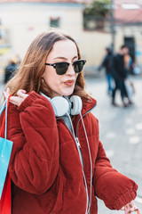 Fototapeta premium Beautiful young girl walks with shopping bags