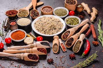 Spices and herbs over black stone background. Top view with free space for menu or recipes