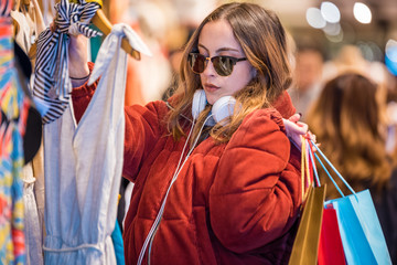 Beautiful young woman chooses clothes clothes Shop