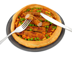Sausage and bean casserole served in a large Yorkshire pudding isolated on a white background