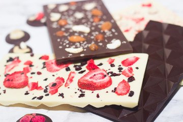 Naklejka na ściany i meble Homemade tasty chocolate on the table. Chocolate with fruits, berries and nuts.