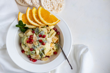 Diet fruit salad for breakfast. Kiwi orange banana and apple diced and seasoned with yogurt with honey. Healthy food, vegetarianism.