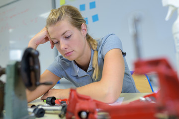 a woman studying mechanical parts